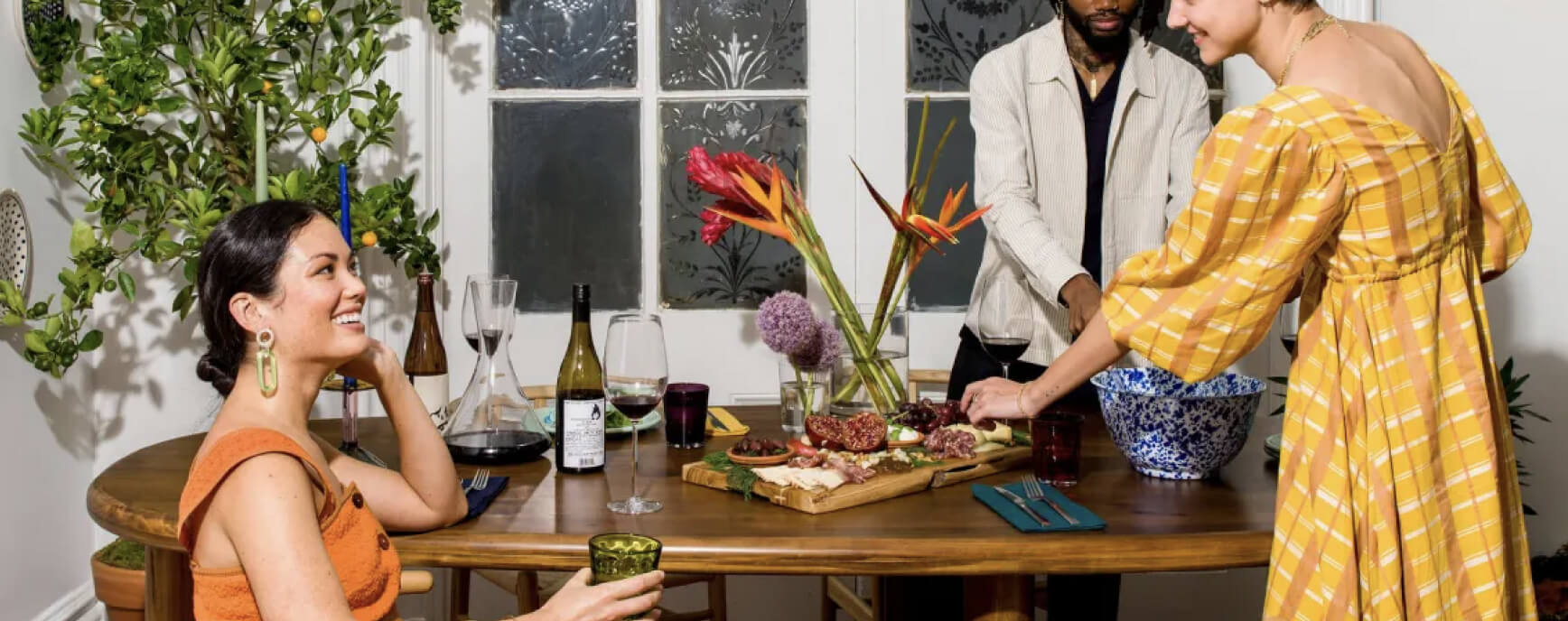 A group of people standing around a wooden table.